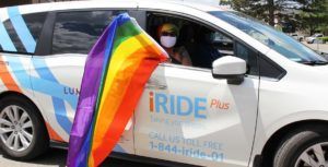 A photo of a Lumacare iRide van with a pride flag