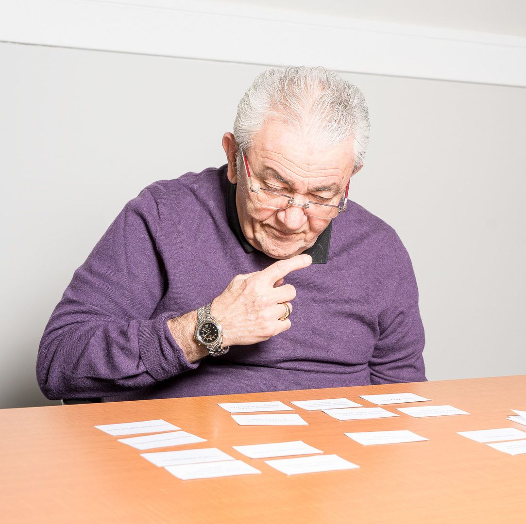 A Lumacare senior playing cards at a table