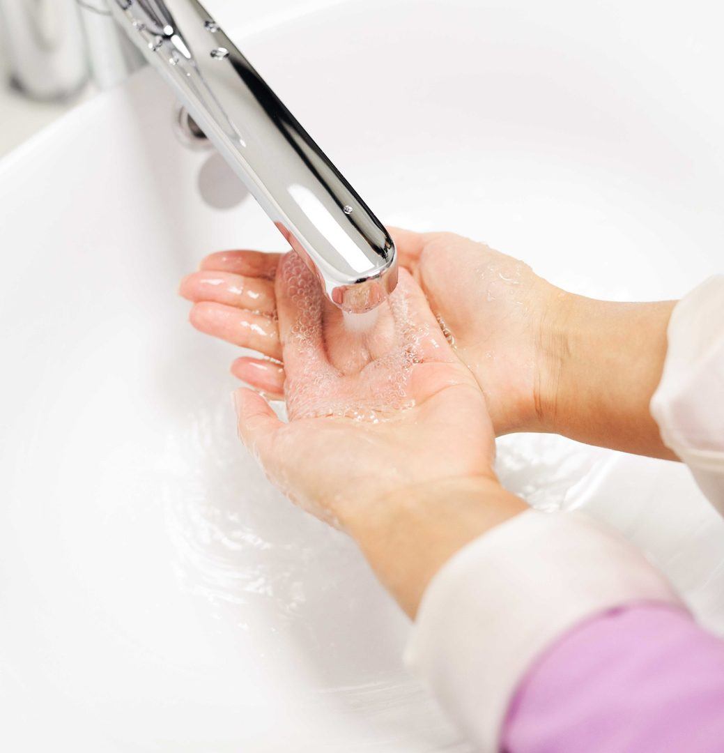 A person washing hands in the sink